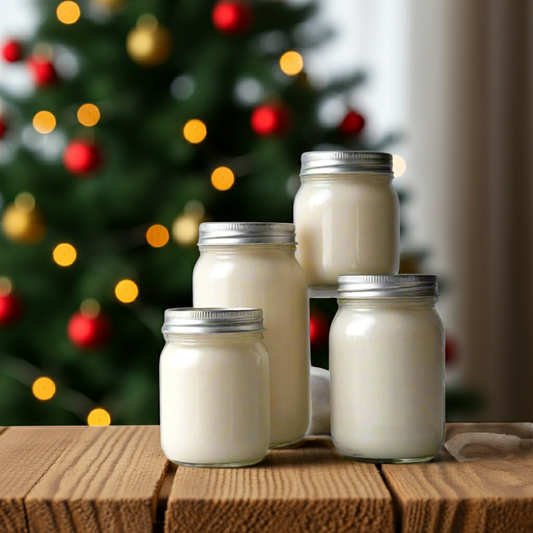 Jars of candles on a wooden surface with a blurred Christmas tree in the background.