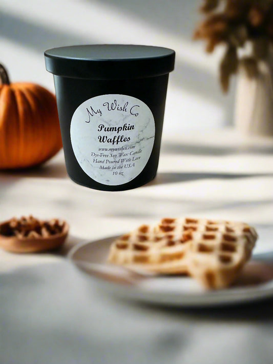 Pumpkin spice candle labeled 'My Wish Co. Pumpkin Waffles' on a table with waffles and pumpkins.