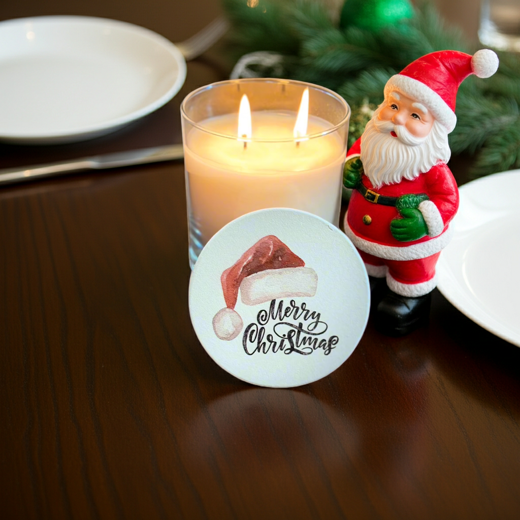 Candle with Santa figurine and 'Merry Christmas' coaster on a table.
