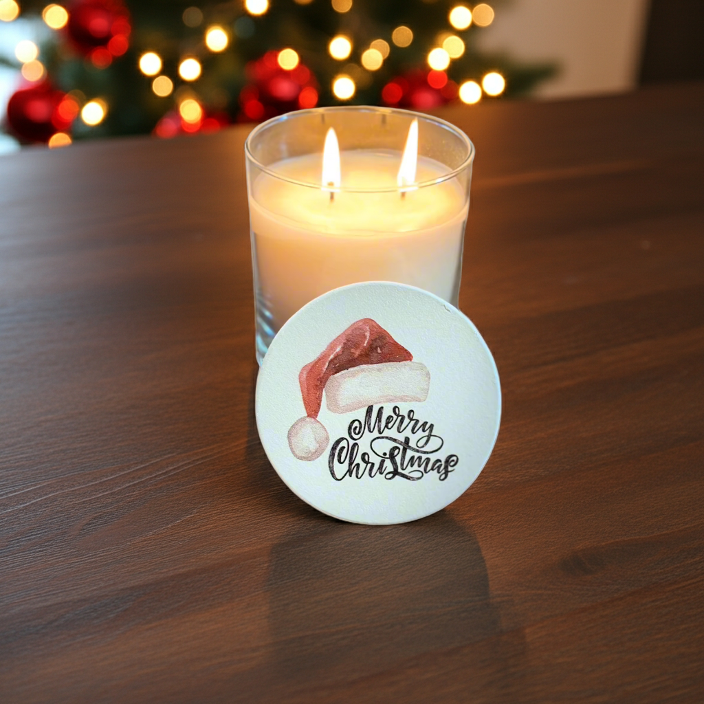 Lit candle with a 'Merry Christmas' coaster on a wooden surface, Christmas lights in the background