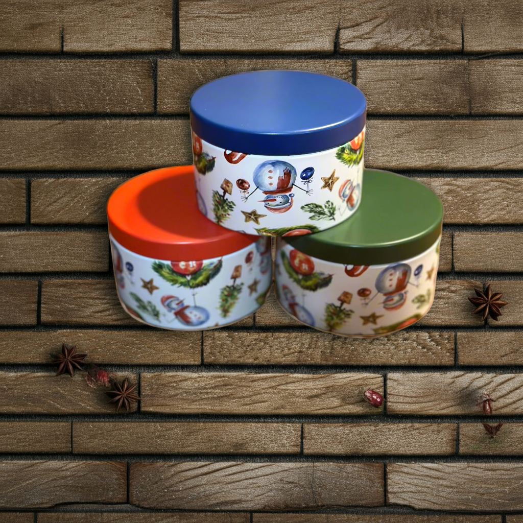 Three decorative tins with colorful lids stacked on a wooden surface