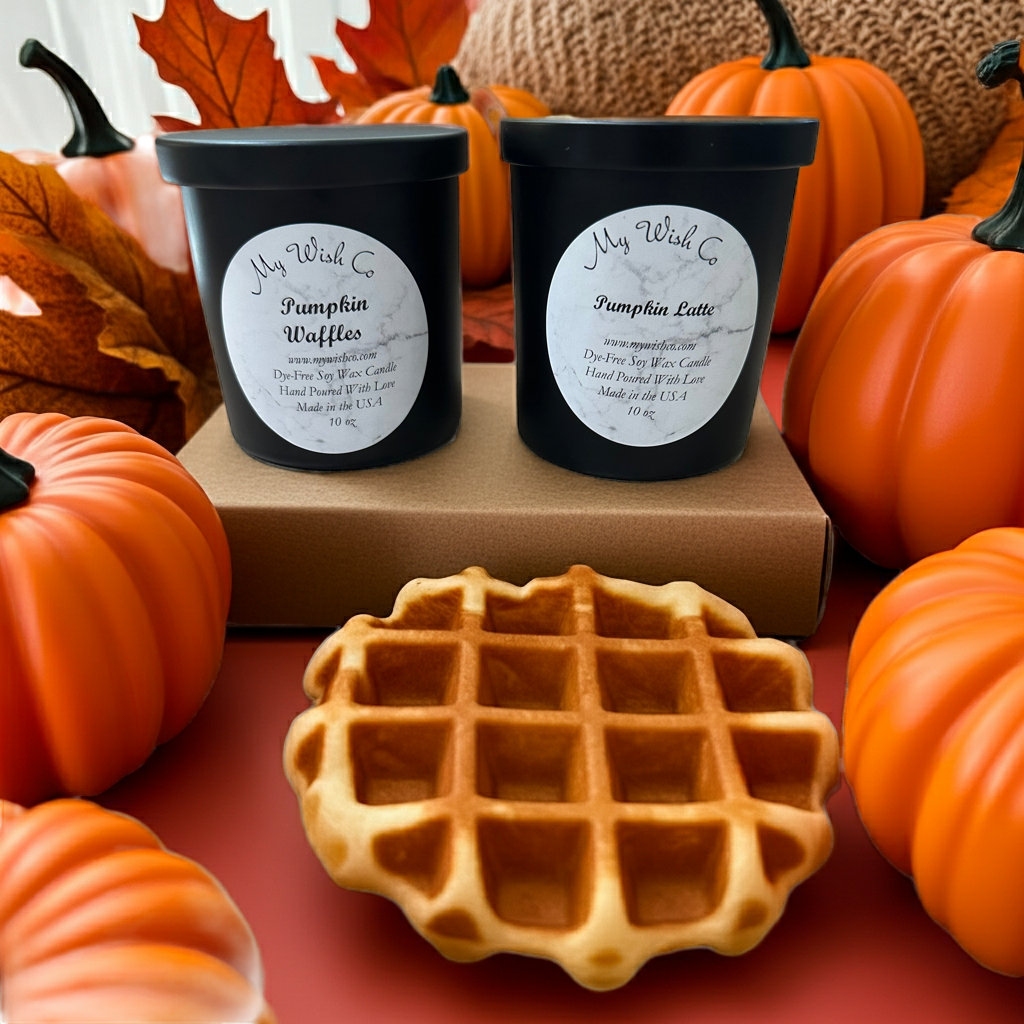 Two black containers labeled 'Pumpkin Waffles' and 'Pumpkin Latte' with a waffle on a red surface surrounded by pumpkins and fall leaves.