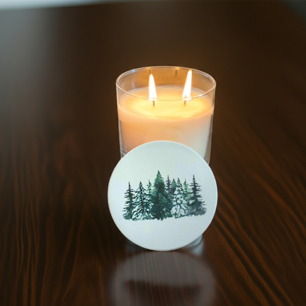 Candle with a forest design coaster on a wooden surface