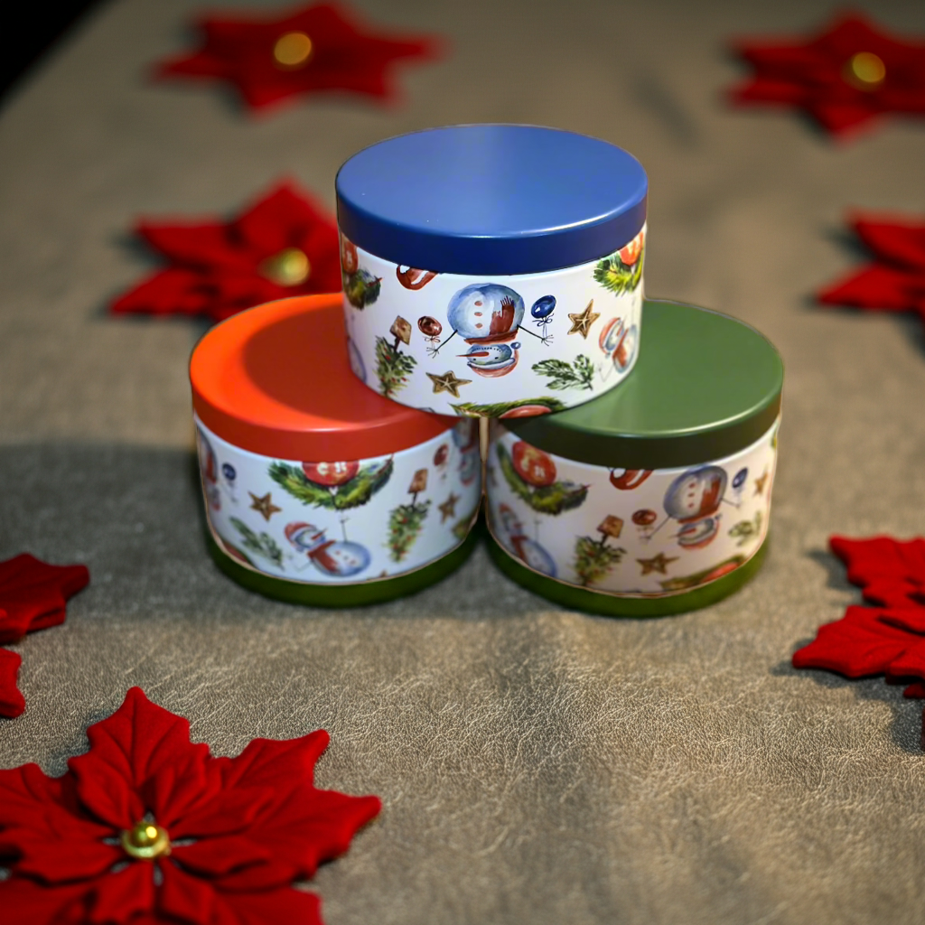 Three cylindrical containers with colorful lids on a textured surface with red floral decorations.