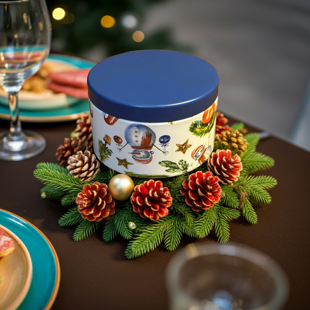 Decorative candle with a blue lid on a table with Christmas decorations