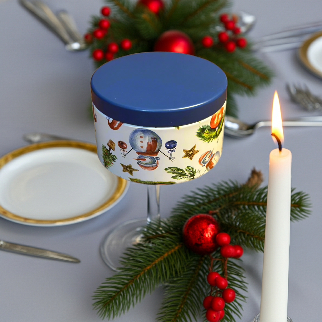 Decorative candle with festive design on a table with Christmas decorations