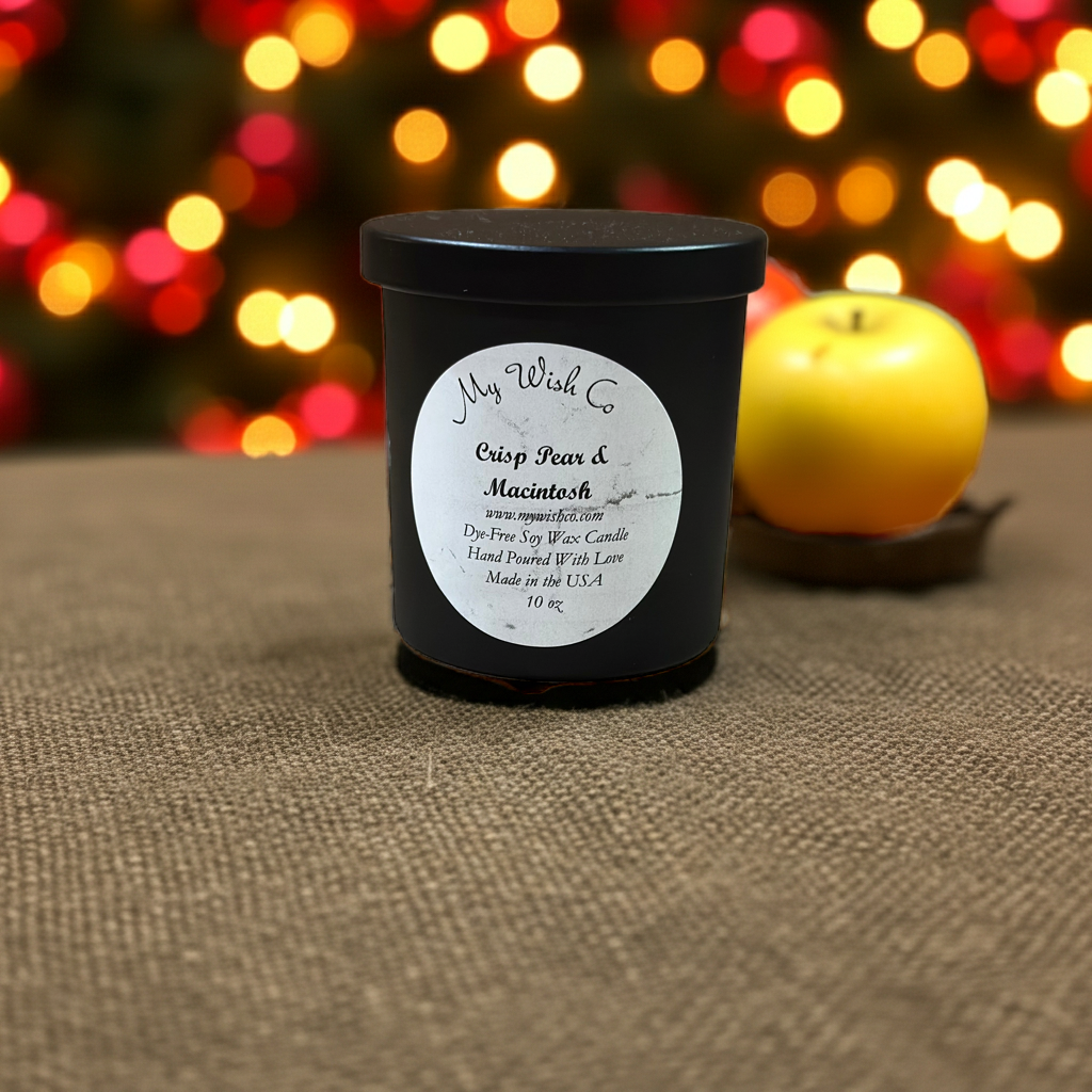 Black candle jar with a label on a textured surface with blurred colorful lights in the background