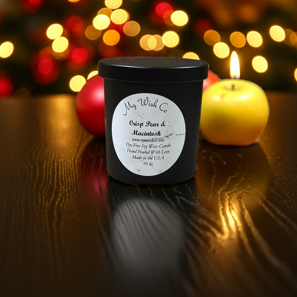 Black candle jar with a label on a wooden surface with blurred lights in the background